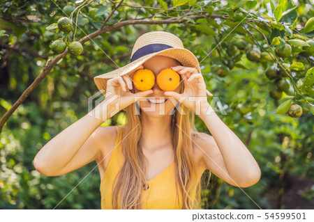 Portrait of Attractive Farmer Woman is Harvesting Orange in Organic Farm, Cheerful Girl in Happiness 54599501