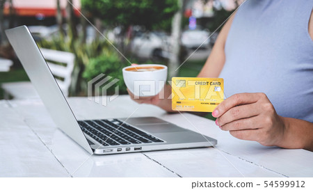 Young woman consumer holding credit card and 54599912