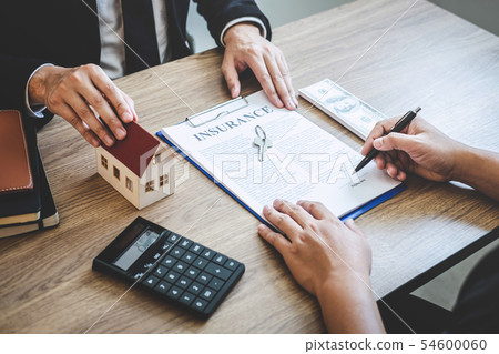Estate agent giving house and keys to client after Estate agent giving house and keys to client after 54600060