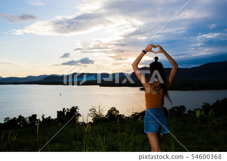 sunset cloud beam to young adult asian woma sunset cloud beam to young adult asian woma 54600368