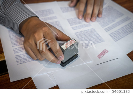 Hands of businessman stamp on paper document to 54601383