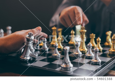 Intelligent businessman playing chess game Intelligent businessman playing chess game 54601388