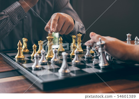Intelligent businessman playing chess game Intelligent businessman playing chess game 54601389