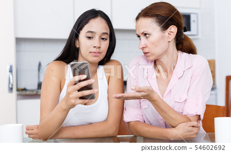 Daughter uses smartphone Daughter uses smartphone 54602692