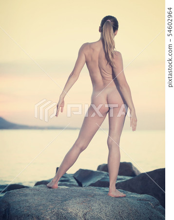 Happy sporty naked female doing aerobics 54602964