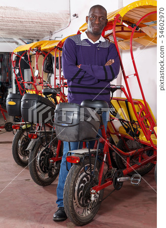 Positive African-American man driver of rickshaw cycle Positive African-American man driver of rickshaw cycle 54602970