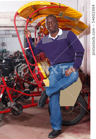Modern driver of pedicab offering touristic tour Modern driver of pedicab offering touristic tour 54602984