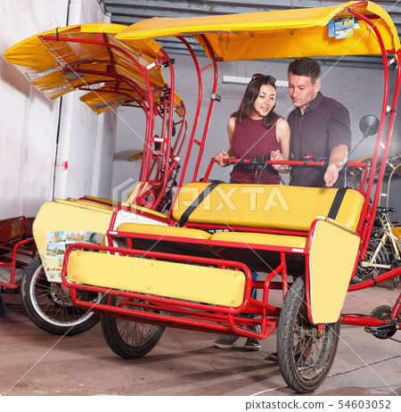 Young family couple planning to hire cycle rickshaw for touristic tour Young family couple planning to hire cycle rickshaw for touristic tour 54603052