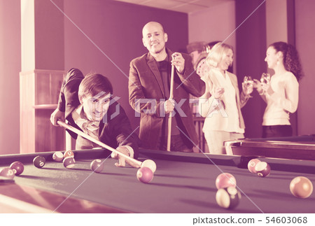 Group of adults playing pool. 54603068