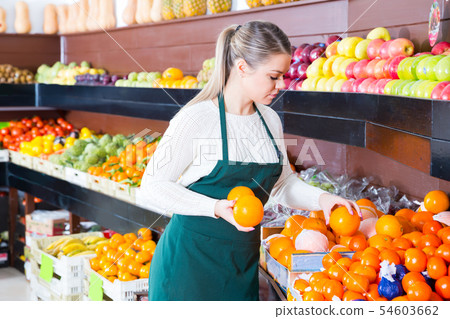 Nice female in apron selling fresh oranges 54603662