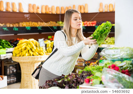 Girl choosing greens in supermarket Girl choosing greens in supermarket 54603692