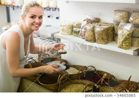 Young female customer buying dried beans Young female customer buying dried beans 54603865