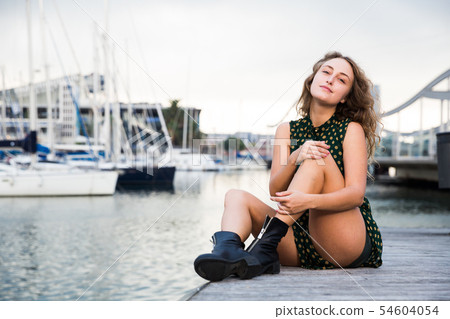 Sexy girl in dress sitting at quay with boats on background in Barcelona 54604054