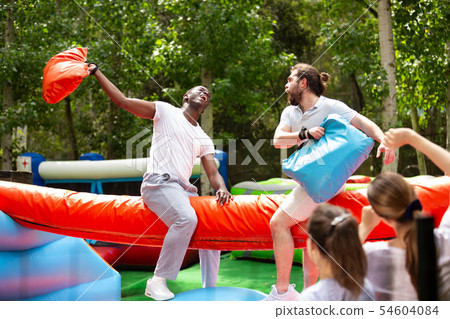 Men on inflatable pillow fight arena 54604084