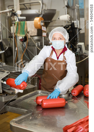 Woman working on sausage automatic line 54604088