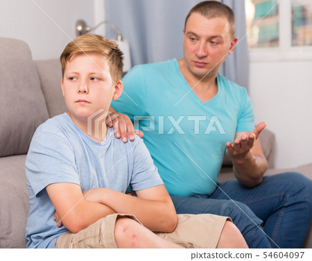 Sad guy with his father are resting and talking about teenage life 54604097