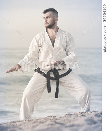Young male is exercising to doing the Shiko-dachi stance 54604169