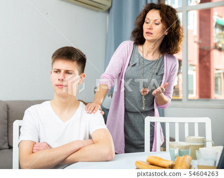 Worried mother talking to son 54604263