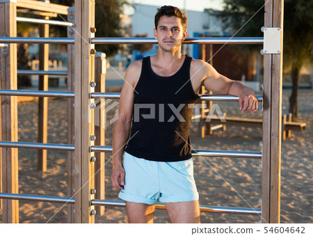 Sporty man near outdoor wall bars Sporty man near outdoor wall bars 54604642