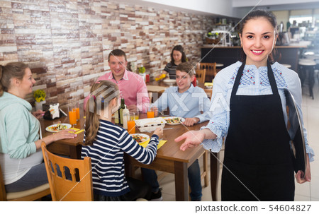 Young hospitable waitress with menu is inviting 54604827