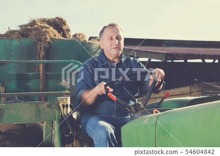 senior male farmer sitting in tractor senior male farmer sitting in tractor 54604842