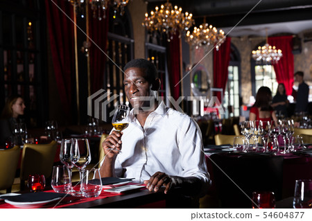 Afro man sitting in restaurant Afro man sitting in restaurant 54604877