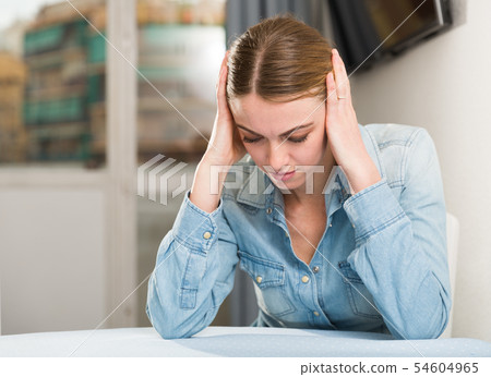 Upset woman sitting at table 54604965