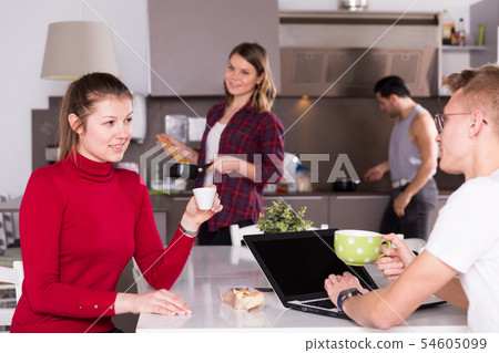 Girl talking to guy in kitchen of hostel Girl talking to guy in kitchen of hostel 54605099