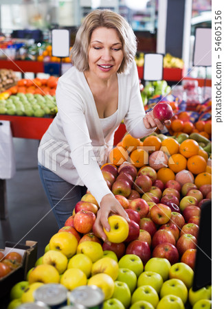 Portrait of smiling woman offering fruits 54605156