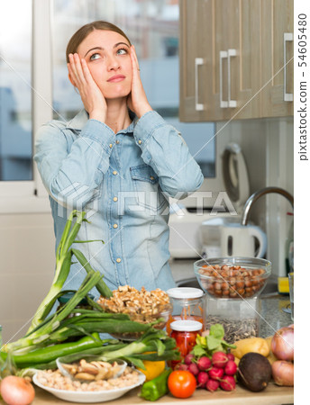 Woman suffering from headache at kitchen Woman suffering from headache at kitchen 54605480