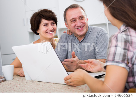 Positive couple listening to woman with laptop 54605524