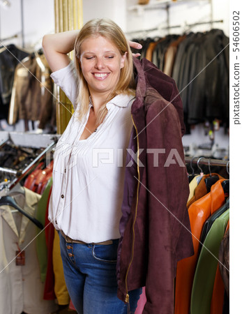 Woman trying on leather jacket Woman trying on leather jacket 54606502