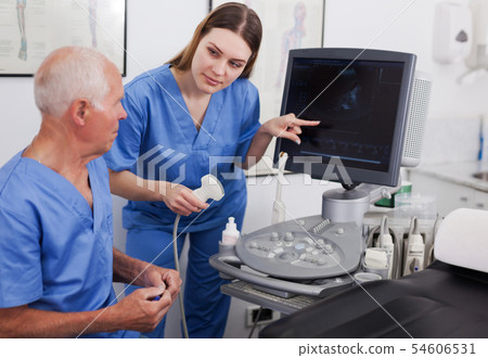 elderly doctor and nurse in cabinet of ultrasound test elderly doctor and nurse in cabinet of ultrasound test 54606531