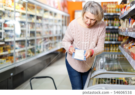 Adult mature woman looking for fish in freezer 54606538