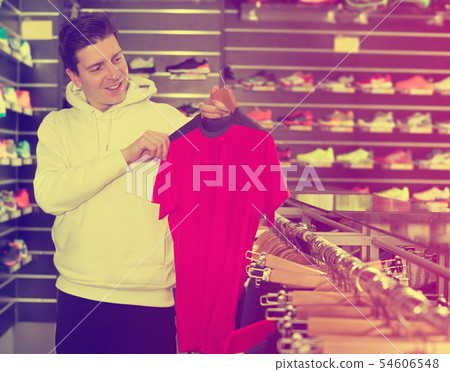 Man is looking on modern shirt for sport Man is looking on modern shirt for sport 54606548