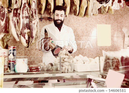 Male shop seller demonstrating jamon Male shop seller demonstrating jamon 54606581