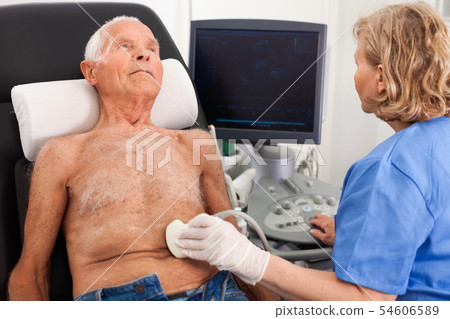 Female technician diagnosing male patient using modern ultrasound scanner in private clinic 54606589