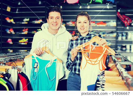 Woman and man are choosing tennis uniform 54606667