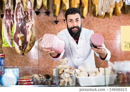 Man seller showing meatloaf in butcher’s shop 54606823