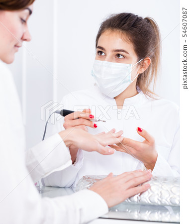 Woman doing shellac manicure Woman doing shellac manicure 54607087