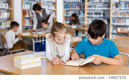 School friends reading books in library 54607378