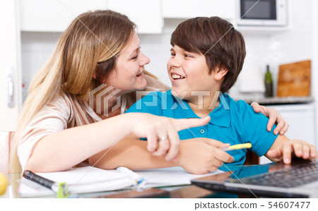 Family doing homework at kitchen 54607477