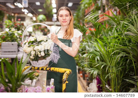 Female florist delivering pots of flowers on a pushcart 54607789