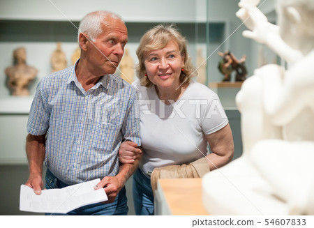 Couple holding brochure at museum Couple holding brochure at museum 54607833