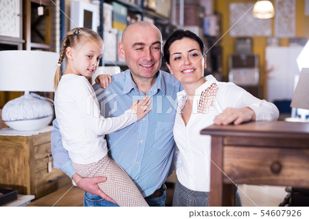 Couple with daughter choosing new furniture in store Couple with daughter choosing new furniture in store 54607926
