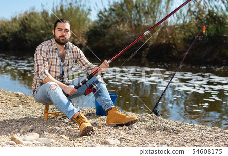 Bearded fisherman fishing on weekend in the river Bearded fisherman fishing on weekend in the river 54608175