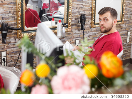 Positive man client sitting at chair in hairdressing salon Positive man client sitting at chair in hairdressing salon 54608230