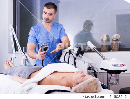 cosmetician explaining hardware treatment 54608342