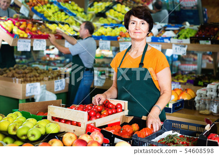 Portrait of smiling woman seller who is standing in the vegetables store. 54608598