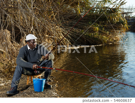 Bored man fishing with rods 54608637